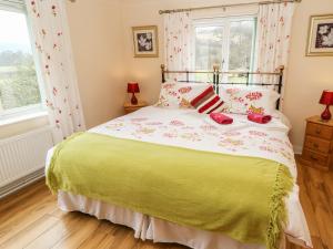 a bedroom with a bed with a green and white bedspread at Broadhay in Hathersage