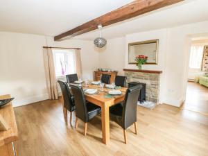 a dining room with a wooden table and black chairs at Broadhay in Hathersage