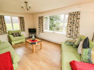 a living room with green furniture and a window at Broadhay in Hathersage