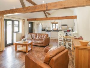 a living room with a couch and a table at Rowdens Barn in Winterborne Stickland