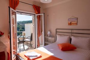a bedroom with a bed and a balcony with a table at Villa Katerina (George) in Séllai