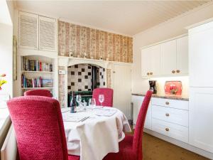 comedor con mesa y sillas rojas en The Barmoor Retreat, en Lowick
