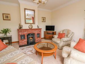 a living room with a brick fireplace and a table at Drainbyrion Farm House in Van