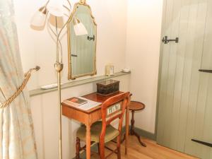 a dressing table with a mirror and a lamp at Tawny Owl Barn in Shipdham