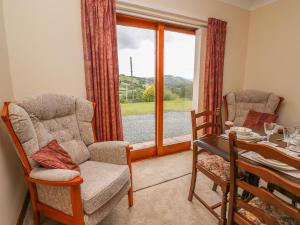 sala de estar con mesa, sillas y ventana en Drainbyrion Farm House en Van