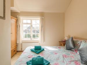 a bedroom with a bed with two green cushions on it at Old Town Cottage in Ludlow