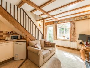 a living room with a chair and a microwave at Old Town Cottage in Ludlow