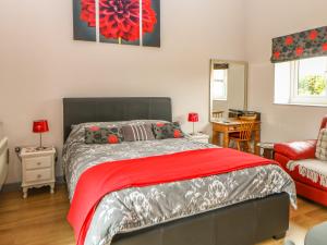 a bedroom with a bed with a red blanket at Snowy Owl Barn in Shipdham