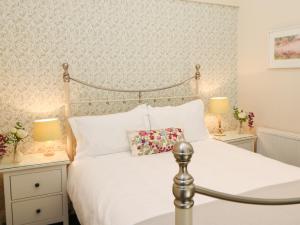 1 dormitorio con 1 cama blanca y 2 mesitas de noche en Old Queen's Head en Wolsingham