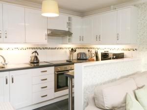 a kitchen with white cabinets and a counter top at Old Queen's Head in Wolsingham