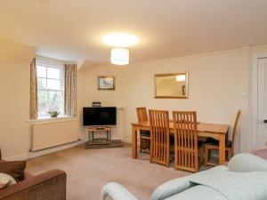 a living room with a table and a television at Stable Flat in New Scone