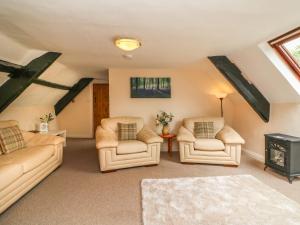 a living room with two chairs and a couch and a table at Fig Trees - Wibble Farm in Williton