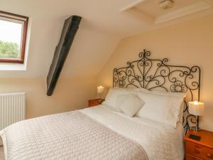 a bedroom with a white bed and a window at Fig Trees - Wibble Farm in Williton