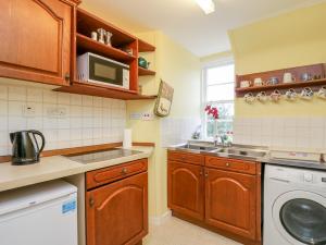 a kitchen with a sink and a washing machine at Stable Flat in New Scone