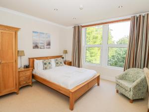 Un dormitorio con una cama y una silla y una ventana. en Eden Lodge, en Bardsea