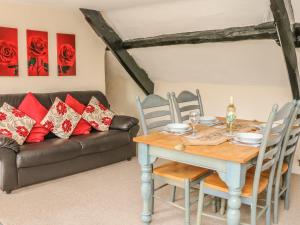 a dining room with a table and a couch at Fig Trees - Wibble Farm in Williton