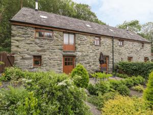 a stone cottage in the middle of a garden at Hendoll Cottage 1 in Fairbourne