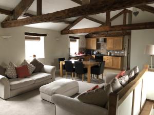 a living room with couches and a table and a kitchen at Carleton Mill with open views to River Eden on the outskirts of Carlisle & 20 mins to Ullswater in Carlisle