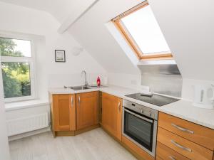 una cocina con fregadero y estufa en Eden Lodge, en Bardsea