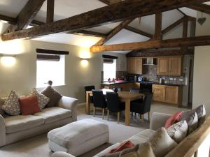a living room with a couch and a table at Carleton Mill with open views to River Eden on the outskirts of Carlisle & 20 mins to Ullswater in Carlisle +2 photos