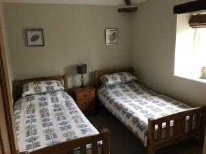 a bedroom with two beds and a window at Carleton Mill with open views to River Eden on the outskirts of Carlisle & 20 mins to Ullswater in Carlisle