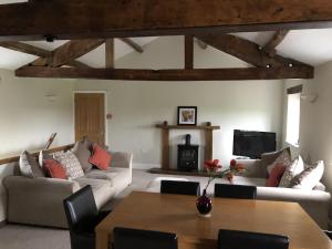 a living room with couches and a table and a fireplace at Carleton Mill with open views to River Eden on the outskirts of Carlisle & 20 mins to Ullswater in Carlisle