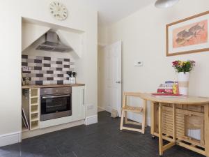 a kitchen with a counter and a table and a stove at Beachgetaway in Rhosneigr