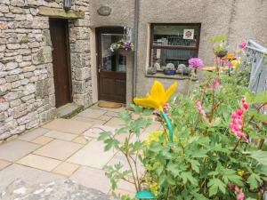 a garden with flowers in front of a door at Horrace Farm Cottage in Pennington