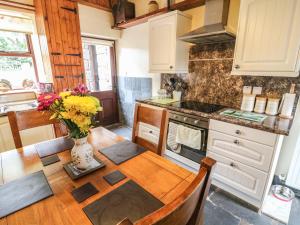 a kitchen with a table and a vase of flowers at Horrace Farm Cottage in Pennington