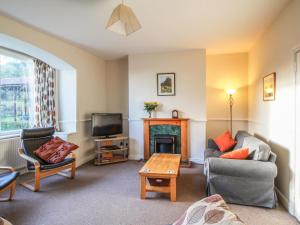 a living room with a fireplace and a tv at Pensychnant Cottage in Conwy