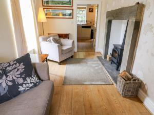 a living room with a couch and a fireplace at Fern House in Kettlewell