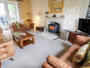 a living room filled with furniture and a fireplace at Fern House in Kettlewell