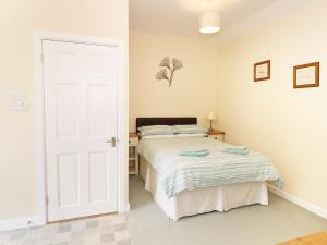 a bedroom with a bed and a white door at The Hideaway at The Barn in Tavernspite