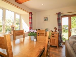 a kitchen and dining room with a wooden table and chairs at Higher Whiddon Farm Whiddon Well in Ashburton