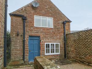 a brick house with a blue door at The Annex - Eden House in Edenhall