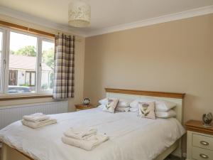 a bedroom with a bed with towels on it at Isla Cottage in Rattray