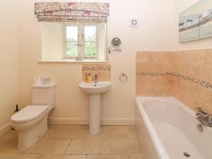 a bathroom with a toilet and a sink and a tub at The Tack Room Cottage in Ashover