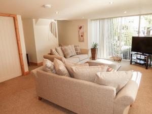 a living room with a couch and a television at The Nook at Timbers in Great Longstone