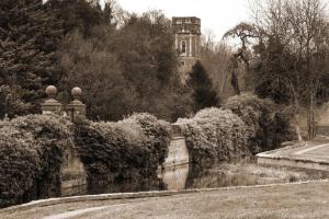 a black and white photo of a garden with a building at Bosworth Hall Hotel & Spa in Market Bosworth