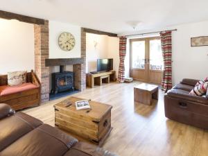a living room with a couch and a fireplace at Little Cow House in Chirk