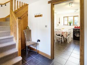 a hallway with stairs and a dining room with a table at Little Cow House in Chirk