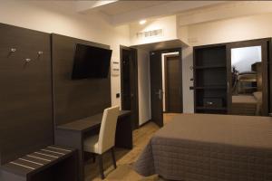 a bedroom with a bed and a desk and a television at Hotel Ristorante Da Tonino in Recanati