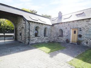 an old stone building with a courtyard in front of it at 3 Bythynnod yr Aran in Bala