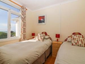 two beds in a bedroom with a window at Highdown in Bigbury on Sea