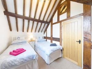 two beds in a room with wooden ceilings at Grafton Mill in Grafton Flyford