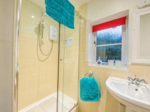 a bathroom with a shower and a sink at Woodpeckers Cottage in Church Stretton +8 photos