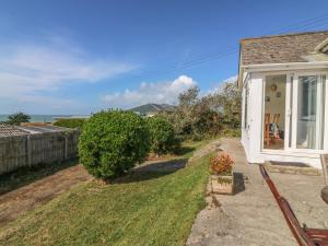 a white house with a yard with a bench at Highdown in Bigbury on Sea