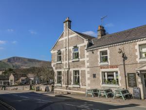 a building with tables and chairs on a street at Talbot House in Castleton