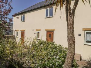 una casa con una palmera delante en 6 Malthouse Court, en Saint Decumans