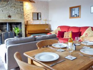 a living room with a table and a couch at Ginnel Corner in Golcar